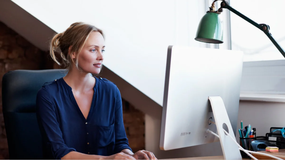 Woman looking at desktop monitor in office